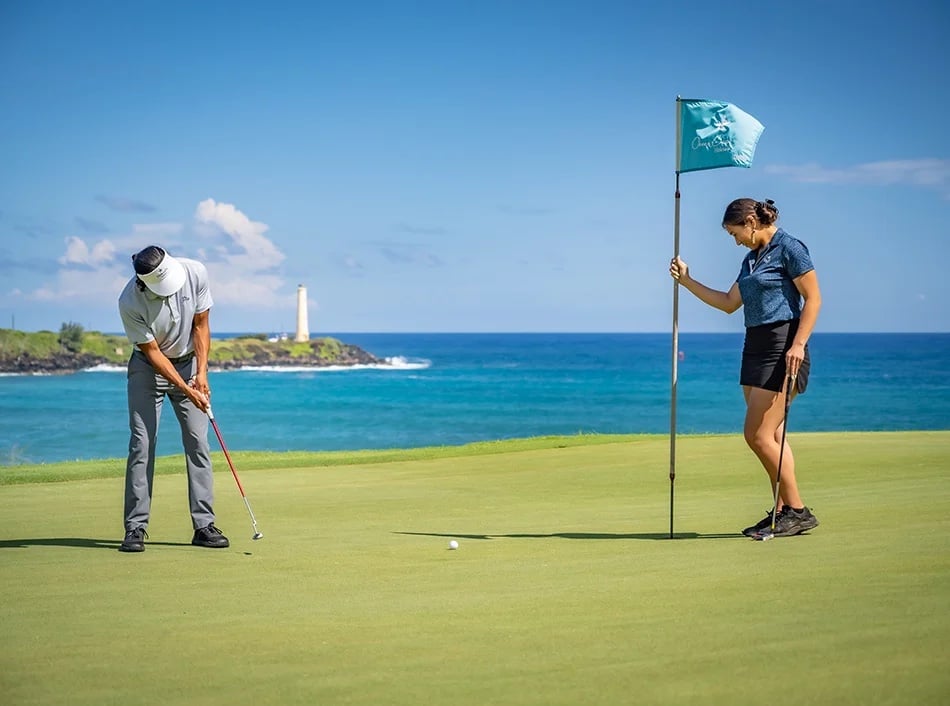 two people putt on a golf course