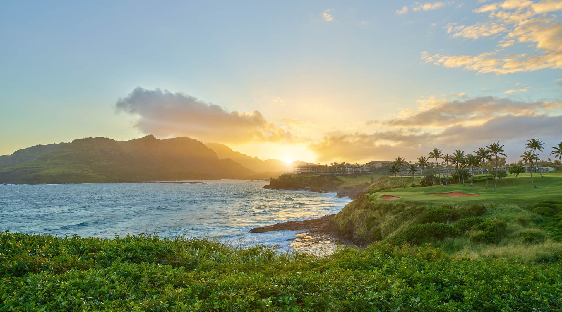 Sunsetting behind Timbers Kauai and the Haupu Mountains on Kauai within the Hokuala Hawaii resort, as viewed from the 14th tee of the Ocean Course at Hokuala